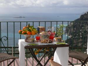 Una mesa con un bol de fruta en un balcón. en L'Uliveto, en Positano