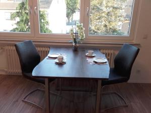 ein blauer Tisch mit zwei Stühlen und zwei Tassen darauf in der Unterkunft Ferienwohnung Kreuder in Bergisch Gladbach
