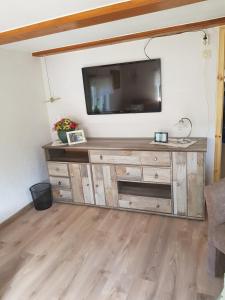 uma sala de estar com televisão numa cómoda de madeira em Am Hechtgraben 5 em Kaupen