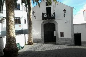 un edificio blanco con una puerta y dos palmeras en Estudio Plaza San Sebastián, en Santa Cruz de la Palma