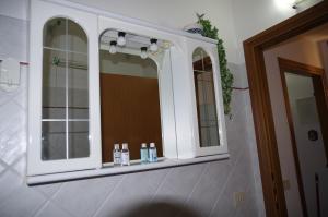 un bagno con un armadietto dei medicinali bianco con due specchi di Residenza Ducale a Ferrara Altre 20 foto