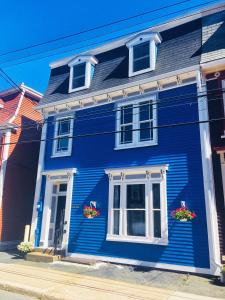 a blue house with flowers in front of it at Gower Manor Historic Bed & Breakfast in St. John's