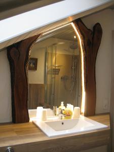 La salle de bains est pourvue d'un lavabo et d'un miroir en forme d'arbre. dans l'établissement Ferienwohnung Zur Parmke, à Schmallenberg