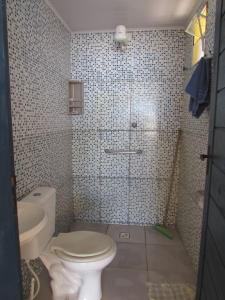 a bathroom with a toilet and a shower in it at Casa c/ Piscina - Ampla e Arejada Balneário Gaivota - 300 mts da Praia in Itanhaém