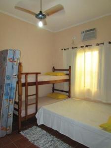 a bedroom with two bunk beds and a fan at Casa c/ Piscina - Ampla e Arejada Balneário Gaivota - 300 mts da Praia in Itanhaém