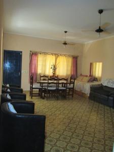 een woonkamer met een tafel en stoelen en een slaapkamer bij Casa c/ Piscina - Ampla e Arejada Balneário Gaivota - 300 mts da Praia in Itanhaém