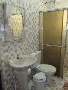 ein Badezimmer mit Waschbecken, Toilette und Spiegel in der Unterkunft Casa c/ Piscina - Ampla e Arejada Balneário Gaivota - 300 mts da Praia in Itanhaém + 19 Fotos