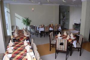 德拉敦Hotel Galaxy的餐厅里有桌椅的餐厅