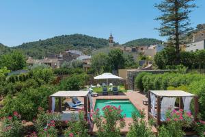 una piscina con sombrillas y sillas en un jardín en Hotel Turixant, en Mancor del Valle