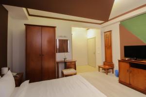 a bedroom with a bed and a flat screen tv at Hotel Aleksandrija in Ohrid