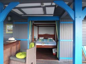 ein Schlafzimmer mit einem Bett in einem Haus in der Unterkunft Les Hauts de la Baie in Terre-de-Bas