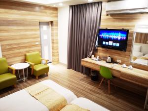 Chengdian Hotel في تايبيه: غرفة فندقية بسريرين وتلفزيون بشاشة مسطحة