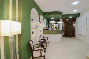 a hallway with green walls and a table and chairs at Hotel Aleksandrija in Ohrid