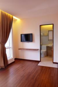 a room with a television on the wall and a bathroom at 9 Square Hotel - Petaling Jaya in Kota Damansara