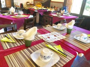 un groupe de tables avec des assiettes, des tasses et des serviettes dans l'établissement Agriturismo Sole di Sicilia, à Randazzo