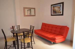 a living room with a red couch and a table at Hotel del Capitán de Puebla - Vitrales in Puebla