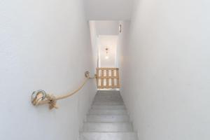 依拉佩特拉的住宿－Rodamos apartment，一条带绳子的楼梯,连在白色的墙上