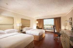 a hotel room with two beds and a window at Barcelo Guadalajara in Guadalajara