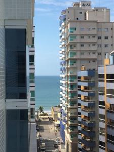 a view of the ocean from a city with tall buildings at Apartamento Meia Praia Itapema in Itapema