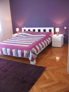 a bedroom with a bed with a purple wall at Apartments Rajna in Split