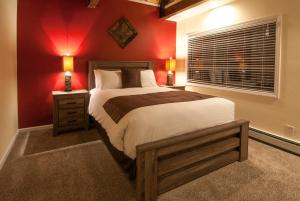 a bedroom with a large bed with red walls at North Lake Lodges & Villas in Incline Village