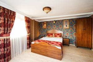 伊斯坦布尔The First Ottoman Suites的壁纸客房内的一间卧室配有一张床