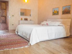 ein Schlafzimmer mit einem weißen Bett und einem Teppich in der Unterkunft B&b A casa di Maybe in Caserta