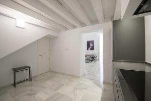 een grote witte kamer met een tafel in de verte bij Casa Columela Cadiz in Cádiz