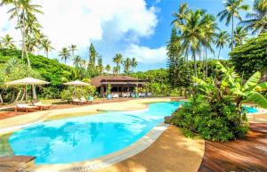 uma piscina num resort com palmeiras em Oure Lodge Beach Resort em Vao