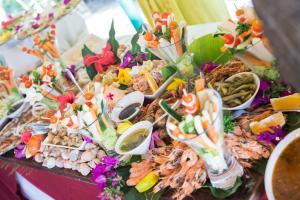 una mesa llena de diferentes tipos de alimentos en Oure Lodge Beach Resort, en Vao