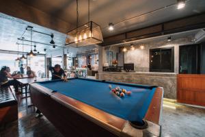a pool table in the middle of a room at Bed & Bike Hostel in Chiang Rai
