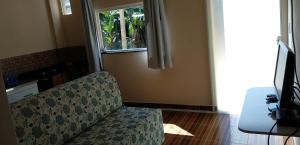 a living room with a couch and a window at Flats Pedra Riscada in Lumiar