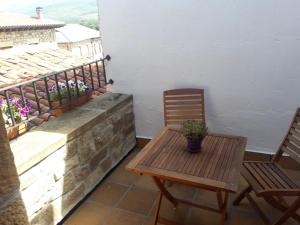 巴努耶薩的住宿－Posada Rural La Piñorra，一个带两把椅子和一张桌子的庭院和一个阳台