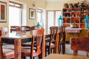 a dining room with wooden tables and chairs at Devra Udaipur in Udaipur +39 photos