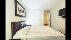 a bedroom with a bed with a leather headboard at Apartment Miraflores Pardo in Lima