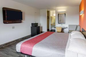 Una habitación de hotel con una cama grande y un televisor de pantalla plana. en Motel 6-Staunton, VA, en Staunton