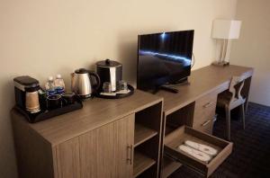 a desk with a television and a coffee maker on it at Hartford Hotel Best Western Signature Collection in Rosemead