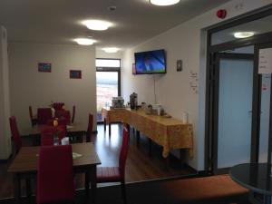 a dining room with tables and chairs and a tv on the wall at Hotel Nowostawy A2 MOP in Nowostawy Dolne