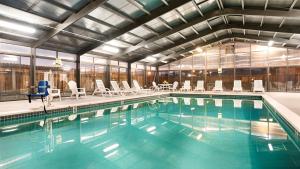 a large swimming pool with chairs and tables and windows at SureStay Hotel by Best Western Fernley in Fernley