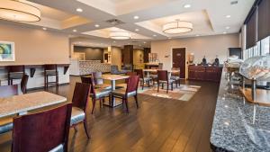 a restaurant with tables and chairs and a bar at Best Western Plus Boardman Inn & Suites in Poland