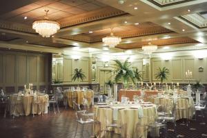 a banquet hall with tables and chairs and chandeliers at Duke Of Cornwall Hotel in Plymouth