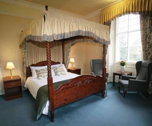 a bedroom with a canopy bed and a chair at Best Western Station Hotel in Dumfries
