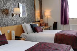 a hotel room with two beds and a mirror at Sure Hotel by Best Western Aberdeen in Aberdeen