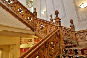 uma escadaria num edifício com um corrimão de madeira em Best Western Queens Hotel em Dundee