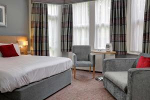 a hotel room with a bed and a chair at Linton Lodge a BW Signature Collection Hotel in Oxford