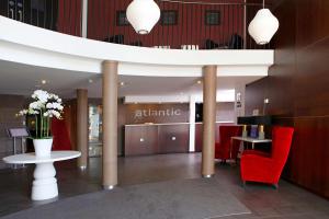 a lobby with red chairs and a table with flowers at Best Western Atlantic Hotel in Chelmsford