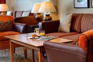 una habitación de hotel con una mesa con una bandeja de comida y vasos en Best Western Plus Milford Hotel, en South Milford