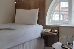 a bedroom with a bed with a window and a phone at Best Western White House Hotel in Watford