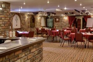 a restaurant with tables, chairs, and tables in it at Best Western Bradford Guide Post Hotel in Bradford