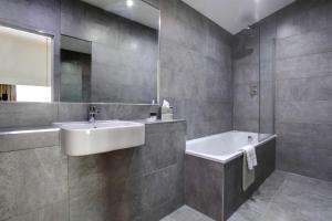 a bathroom with a sink and a tub and a mirror at Best Western Atlantic Hotel in Chelmsford